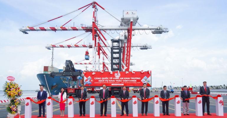 Dignitaries gathered at LAIP in front of cranes and a vessel at berth