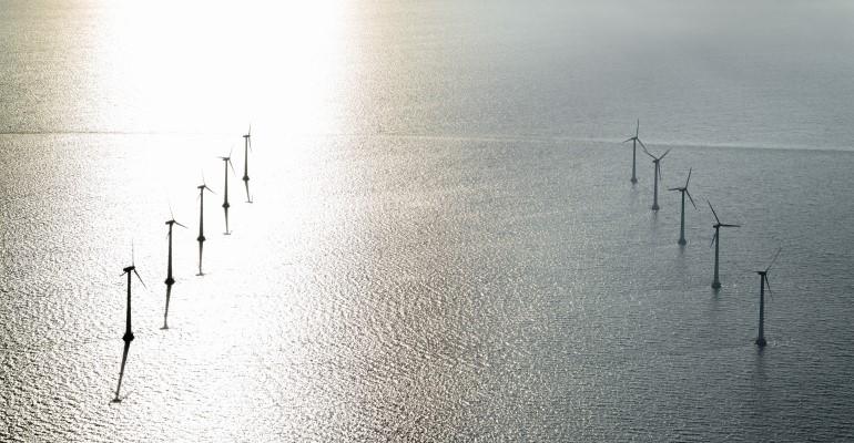 Wind turbines out at sea at Tunoe Knob, highlighted by the sun's reflection off the water