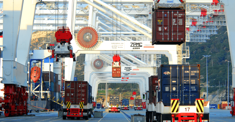White ZPMC cranes move containers at Tanger Med with trucks below