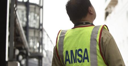 An AMSA inspector looks up at a vessel